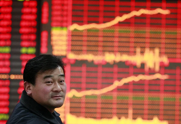 2016 日中国東部の安徽省淮北市証券家で上海総合指数を示す電子ディスプレイの前に中国の投資家に見える — ストック写真