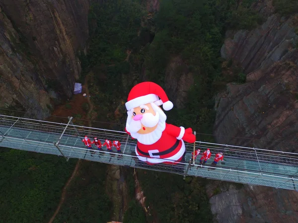 サンタクロースの衣装を着た中国人従業員は180 Pingjiang ユエヤン市 Shiniuzhai 国立ジオパークで 高さ10メートルの サンタクロース と300メートルの長さのガラス底の吊り橋で — ストック写真