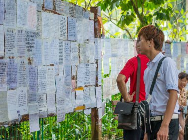 Young Chinese men look at posts showing personal information of unmarried people at the Matchmaking Corner in a park in Shenzhen city, south China's Guangdong province, 6 October 2015. clipart