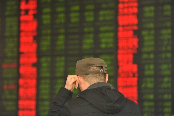 2016 日中国東部の安徽省阜陽市の証券会社の家で 赤の価格上昇 と価格下落のため緑の株式の価格を見て懸念している中国語の投資家 — ストック写真