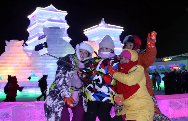 2016年1月5日 在中国东北黑龙江省哈尔滨市举行的第32届哈尔滨国际冰雪节上 游客们在巨大的冰雕前自拍自拍 — 图库照片