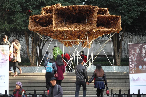 2014年12月6日 在中国东部浙江省杭州市的中国艺术研究院门前 行人正在看一幅由落叶制成的喇叭形艺术品 — 图库照片