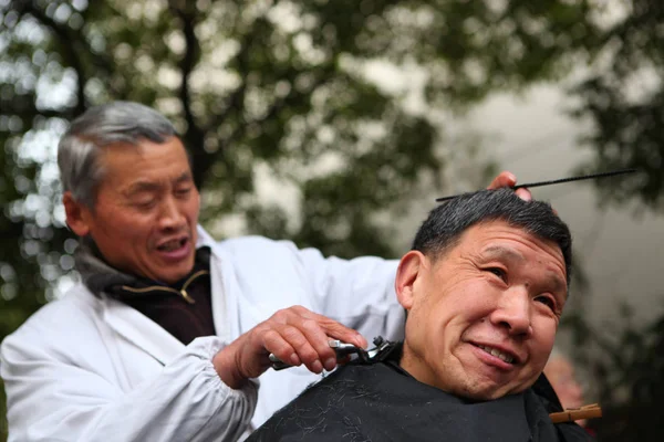 中国の床屋が上海で顧客のために髪を切る 2015年3月14日 — ストック写真