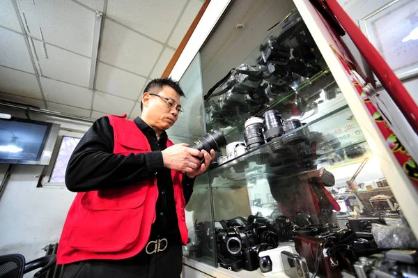 中国の修理ベテランZhan Chunmingは 中国の北京の彼の店でレンズをチェックします 2016 — ストック写真