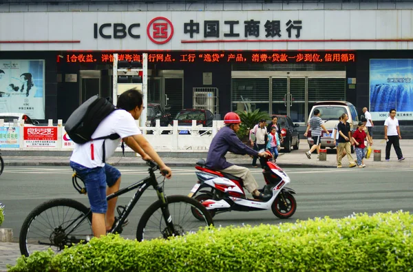 骑自行车的人从中国工商银行 Icbc 位于中国中部湖北省宜昌市的一家分行经过 2015年9月9日 — 图库照片