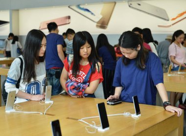Customers look at iPhone 6 smartphones at an Apple Store in Hangzhou city, east China's Zhejiang province, 21 September 2015 clipart