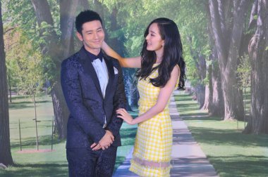 Chinese actress Yang Mi, right, looks at actor Huang Xiaoming during a press conference for their new movie 