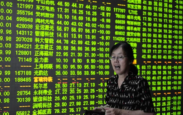 2015年6月26日 在中国东部浙江省杭州市一家股票经纪公司 一位关心此事的中国投资者走过显示股价 绿色价格下跌 的屏幕 — 图库照片