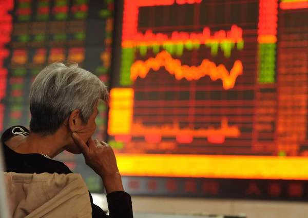 2015 日中国東部の安徽省阜陽市で証券家で株価指数を見て懸念している中国語の投資家 — ストック写真