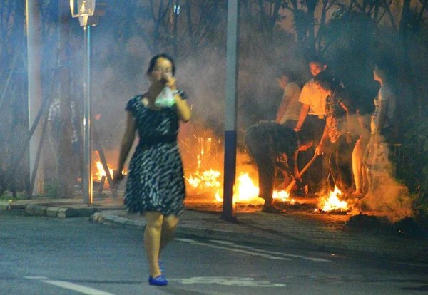 2014年8月10日 在中国东部安徽省合肥市 一位行人在路边用手捂住嘴和鼻子 走过人们烧着纸钱的人 悼念他们的亲人 — 图库照片