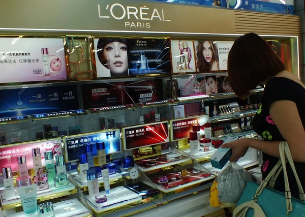 2013年8月27日 中国中部の湖北省 江昌市のショッピングモールにあるロレアルの化粧品店で客が買い物をする — ストック写真