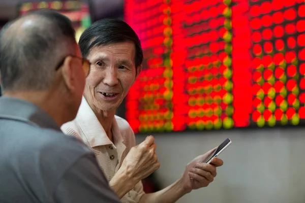 Китайський Інвестора Посмішок Він Переговори Іншими Перед Екраном Відображення Цін — стокове фото