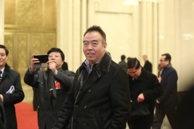 Chinese director Chen Kaige, center, arrives at the Great Hall of the People to attend the opening meeting of the Third Session of the 12th NPC (National People's Congress) in Beijing, China, 5 March 2015 clipart