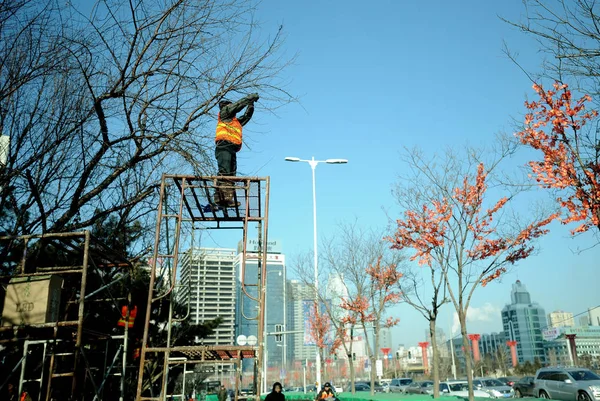 Chinese Worker Prepares Tie False Green Leaves Bare Branches Tree — Stock Photo, Image