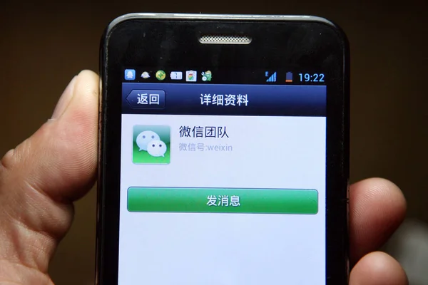 2013년 22일 상하이의 스마트폰에서 휴대폰 사용자가 텐센트의 모바일 메시징 Weixin — 스톡 사진