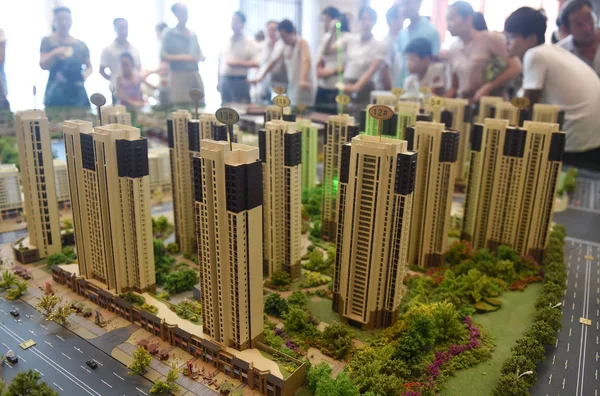 2015年8月2日 在中国中部河南省洛阳市举行的房地产博览会上 中国购房者正在查看住宅公寓楼的模型 — 图库照片