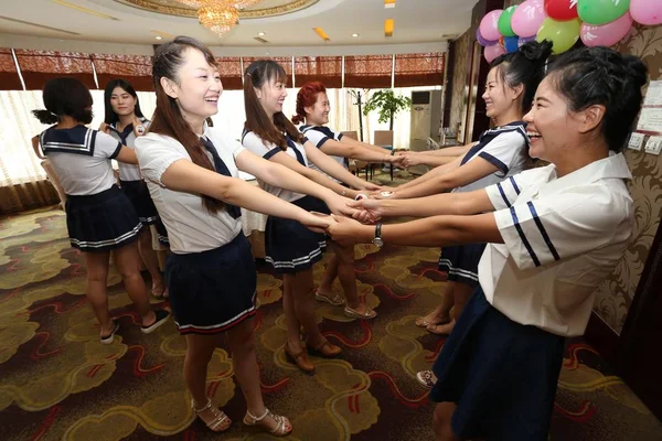 学校の制服を着た若い中国人の母親は 中国の山東省 Weifang 市でキャンパス生活をリコールするパーティーで反応します 月2015 — ストック写真