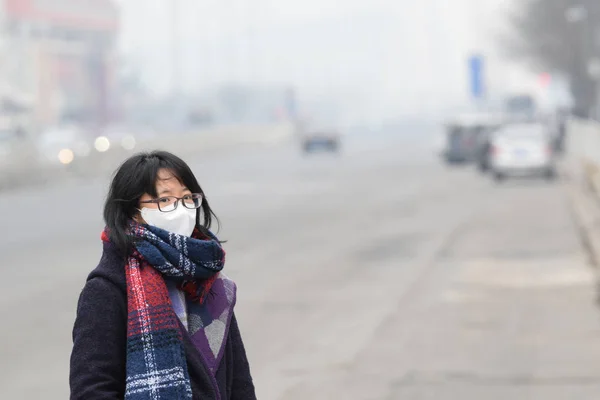 2015年12月7日 在中国北京 一名戴着口罩的行人在浓烟中走在路上 — 图库照片