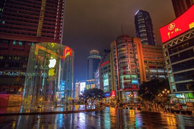 View of an Apple store in Jiefangbei CBD, also known as Jiefangbei Commercial Walking Street on a rainy night in Chongqing, China, 22 May 2015. clipart