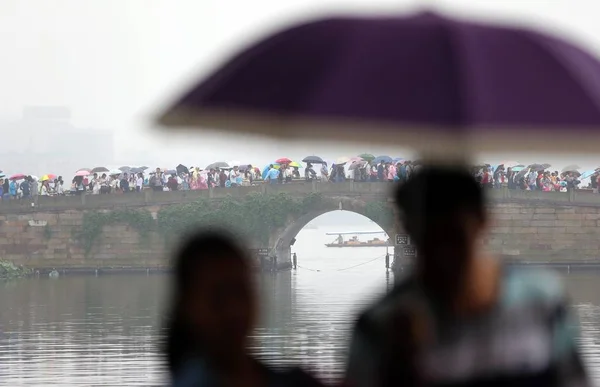 Turisti Che Tengono Ombrelli Piedi Attraverso Ponte Rotto Sul Lago — Foto Stock