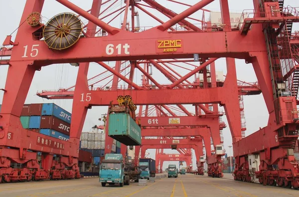 クレーンは 中国東部江蘇省梁雲江市の梁雲江港でトラックにコンテナを降ろします 2015年3月14日 — ストック写真