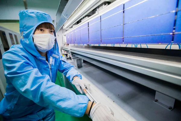 2015年2月25日 中国東部江蘇省麗陽市の上海深州新エネルギー開発有し合いの工場で 太陽光パネルを作るのに使われた太陽光発電 セルを中国人女性がチェック — ストック写真