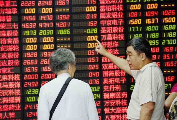Китайские Инвесторы Говорят Перед Дисплеем Показывающим Цены Акции Красный Роста — стоковое фото