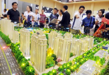 Chinese homebuyers look at housing models of a residential property project at a real estate fair in Taiyuan city, north China's Shanxi province, 28 August 2015 clipart