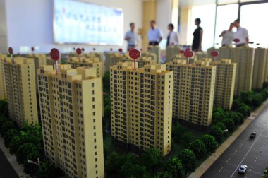 Chinese homebuyers look at models of residential apartment buildings during a real estate fair in Qingzhou city, east China's Shandong province, 14 August 2015 clipart