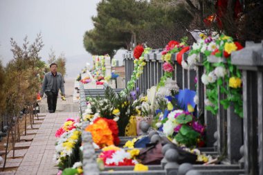 Bouquets of flowers are laid on tombs at a cemetery during the Qingming Festival in Shanghai, China, 4 April 2015 clipart