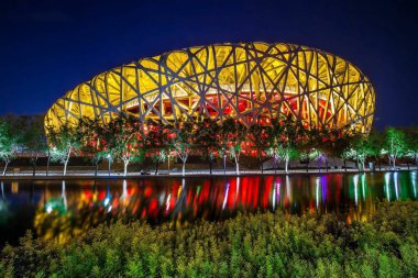 Night view of the Beijing National Stadium, back, also known as the Bird's Nest, in the Olympic Green in Beijing, China, 27 May 2014. clipart