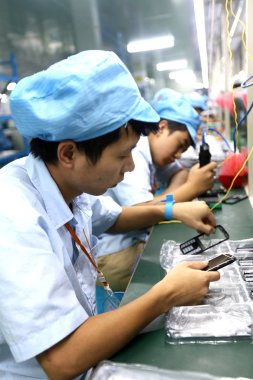 Chinese workers assemble digital products at a plant in Huaying city, southwest China's Sichuan province, 7 October 2015 clipart