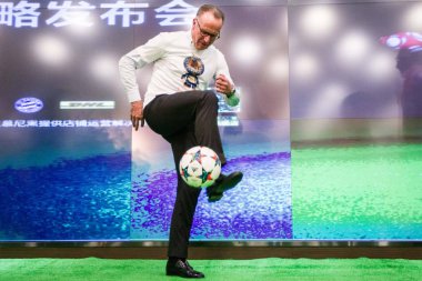 Karl-Heinz Rummenigge, chief executive officer of the FC Bayern Munich, shows off his football skills during a press conference for the strategic cooperation between FC Bayern Munich and Tmall, the B2C platform of Chinese e-commerce giant Alibaba Gro clipart