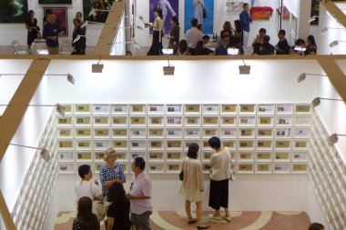 Visitors talk and view photographs on display during a preview of the Photo Shanghai 2015 in Shanghai, China, 10 September 2015 clipart