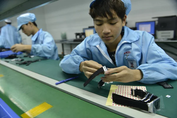中国の労働者は 深セン市のホープテクノロジーの工場で組み立てラインにスマートウォッチを組み立てます 中国南部の広東省 2015年4月22日 — ストック写真