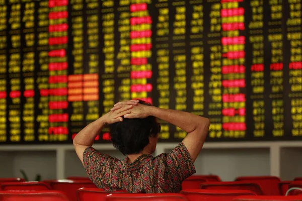 2015 日中国南部の海南省海口市の証券の家で 赤の価格上昇 と価格下落のため緑の株式の価格を見て懸念している中国語の投資家 — ストック写真