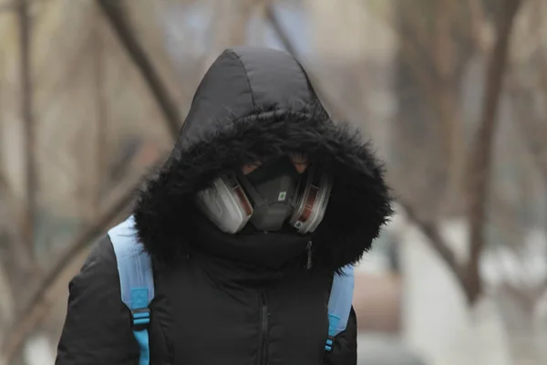 ガスマスクをかぶった歩行者が 2015年12月8日 北京の重いスモッグの通りを歩く — ストック写真
