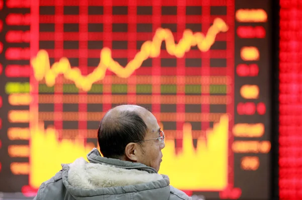 2015年12月14日 在中国东部安徽省淮北市的一家股票经纪公司 一位中国股票投资者看着显示股价 红色代表价格上涨 价格下降为绿色 的屏幕 — 图库照片