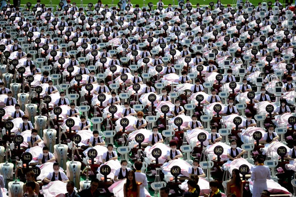 在中国东部山东省济南市山东省体育中心体育场举行的 吉尼斯世界纪录 宣传活动中 美容师们对女性参与者进行面部护理 — 图库照片