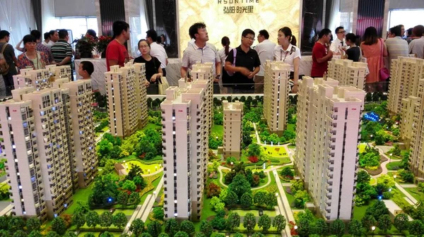 2015年5月23日 在中国东部江苏省淮安市举行的房地产博览会上 一名中国员工向购房者介绍了住宅楼的模型 — 图库照片