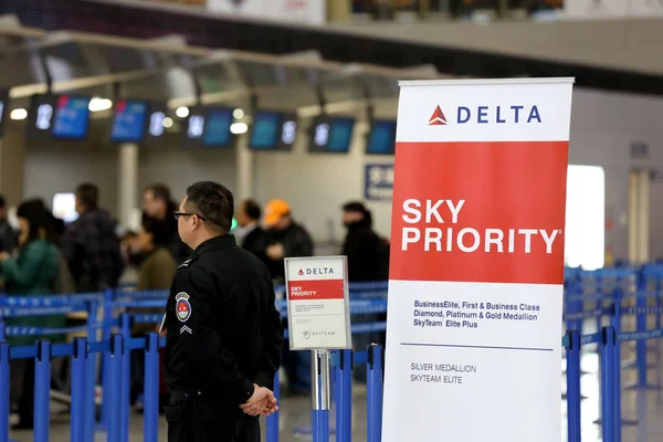 File Chinese Security Guard Stands Next Poster Delta Air Lines — Stock Photo, Image