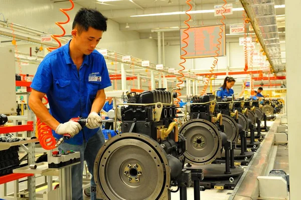 中国の労働者は 2015年6月3日 中国東部の山東省青州市の自動車工場で組み立てラインにエンジンを組み立てます — ストック写真
