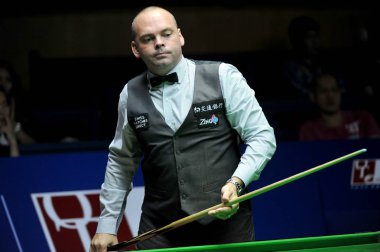 Stuart Bingham of England considers a shot against Fang Xiongman of China during their first round match of the 2015 World Snooker Shanghai Masters in Shanghai, China, 15 September 2015 clipart