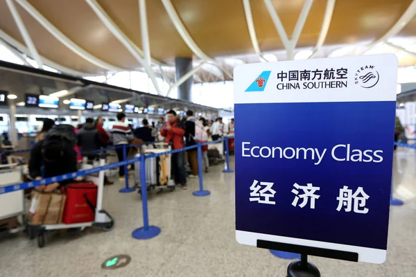 乗客が 2015 上海に上海浦東国際空港で中国南方航空のカウンターでチェックインに並ぶ — ストック写真