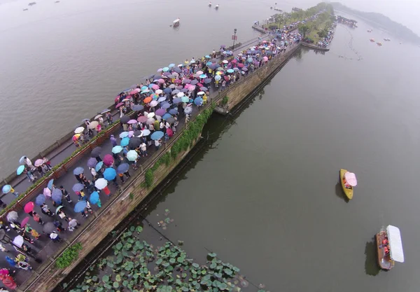 Turisti Che Tengono Ombrelli Piedi Attraverso Ponte Rotto Sul Lago — Foto Stock