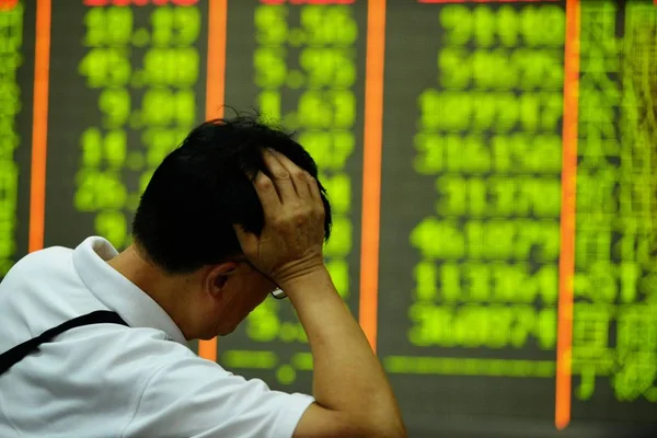 2015 日中国東部の浙江省杭州市の証券会社の家で株式の 価格下落のためグリーン の価格を見て懸念している中国語の投資家 — ストック写真