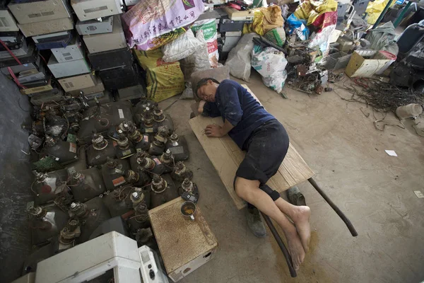 Chiński Pracownik Spoczywa Obok Elementów Elektrycznych Zdemontowanych Zestawów Telewizyjnych Rur — Zdjęcie stockowe