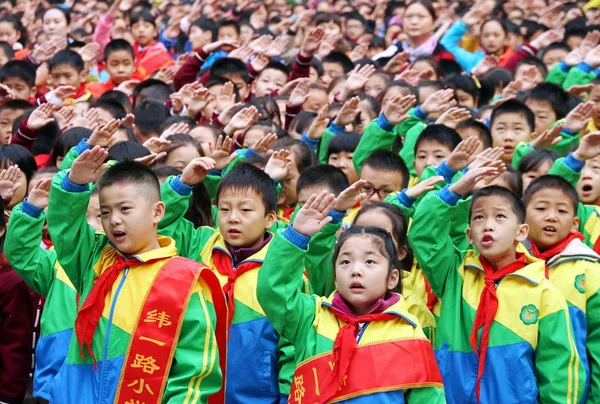 ファイル 若い中国語中国の若い開拓者の学生に敬意を表するし 2014 日中国中部の河南省鄭州市で小学校で国旗掲揚式典中に国立置きましたを歌う — ストック写真