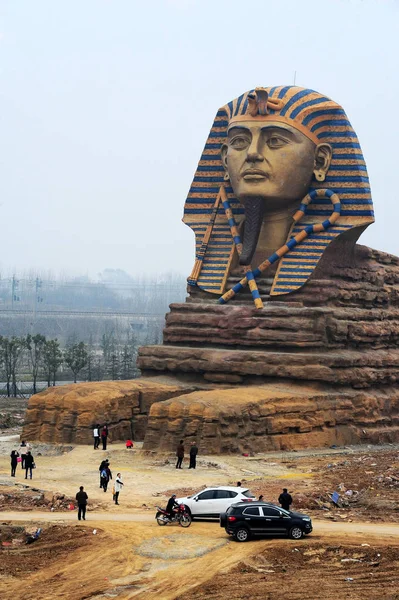 stock image Visitors walk past the replica of the Great Sphinx at the construction site of Chuzhou Great Wall International Tourism Cartoon Creative Park in Chuzhou ctiy, east China's Anhui province, 14 March 2015