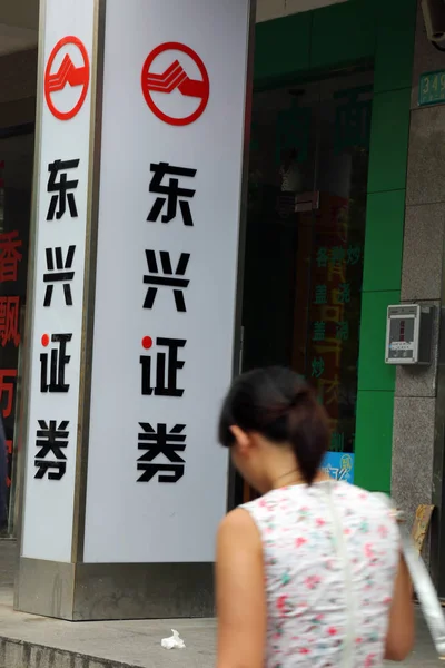 2014年8月6日 一位行人走过东兴证券位于中国上海的一家分行 — 图库照片
